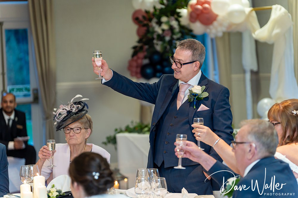 Man toasting at wedding reception.