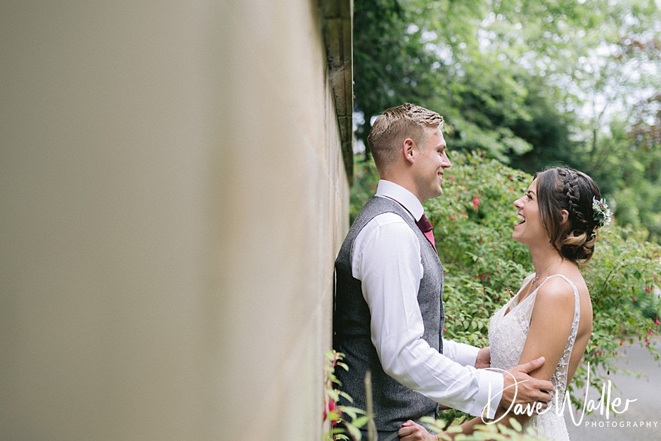 A joyful couple sharing a loving glance, surrounded by greenery on their wedding day.