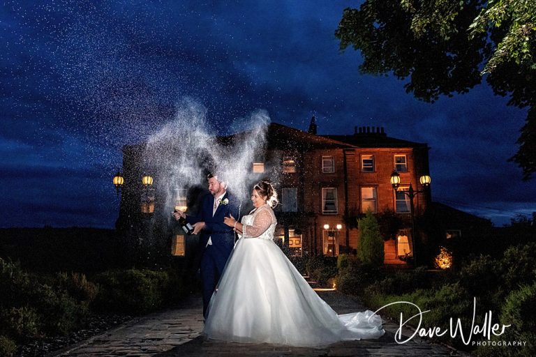 A magical evening: Sanchia and James, newlyweds, celebrate under a starlit sky with a sparkling champagne toast outside an elegant manor house at Waterton Park.