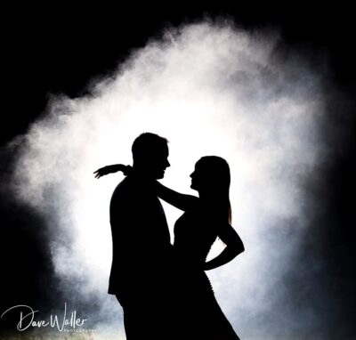 A romantic silhouette of a couple against a luminous misty backdrop, capturing an intimate dance moment.