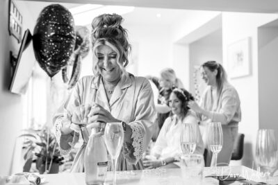 Women preparing for a celebration, opening champagne bottle