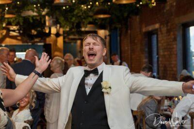 Man in tuxedo celebrating at event.
