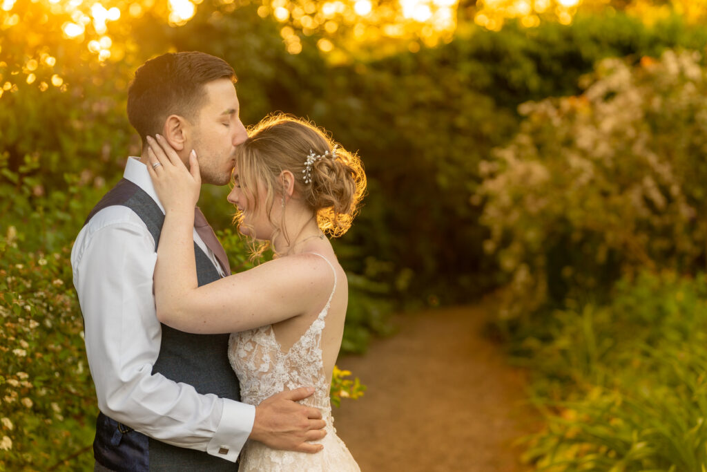 Couple embracing at sunset in garden wedding.
