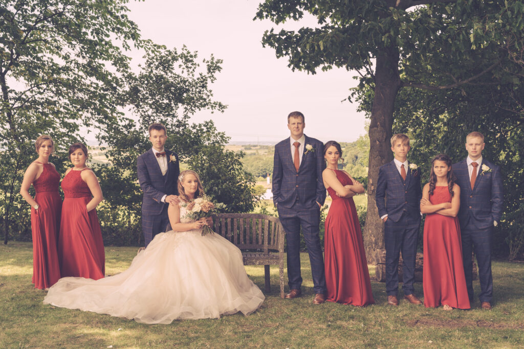 Wedding party posing outdoors in formal attire.