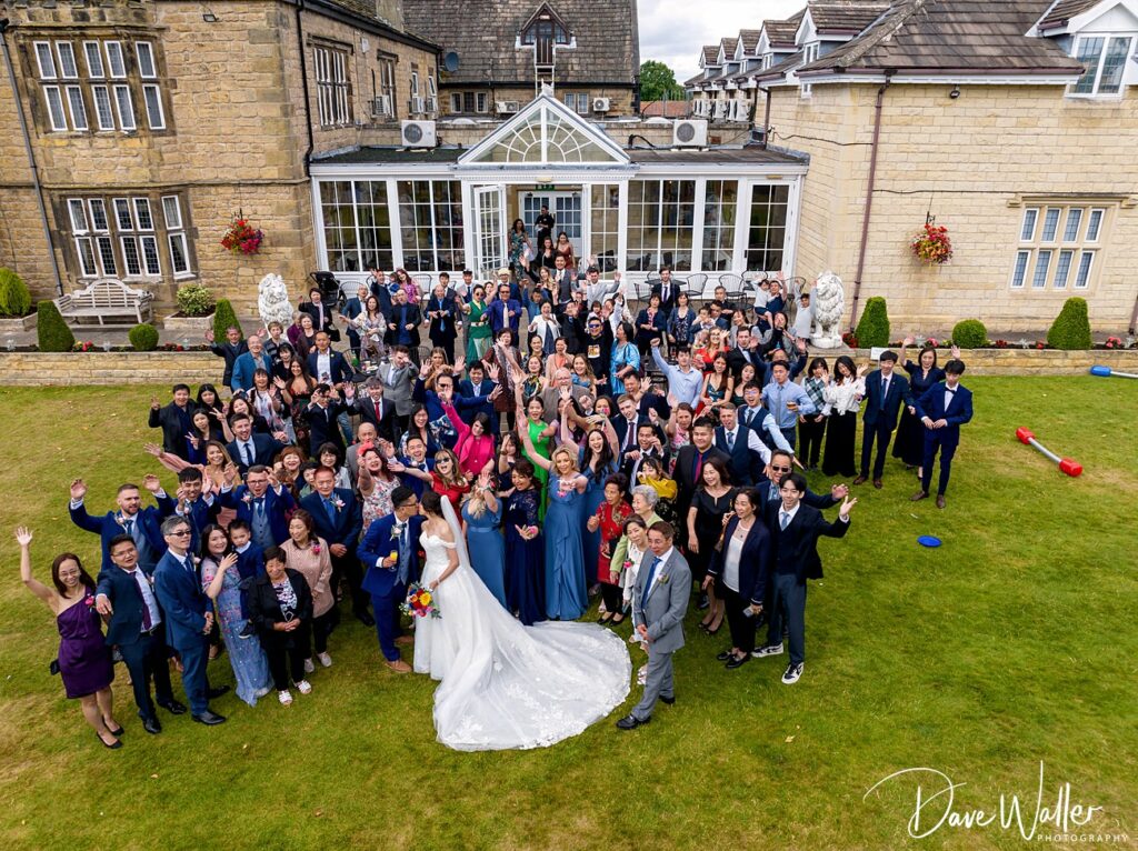 Large wedding group outside manor house