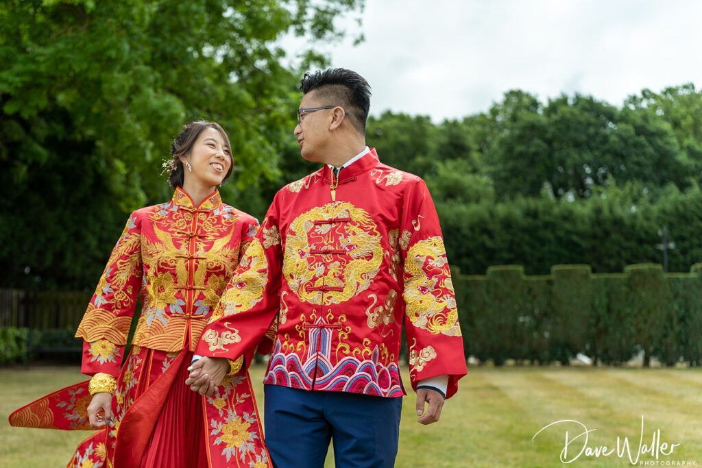 Couple in traditional Chinese wedding attire outdoors.