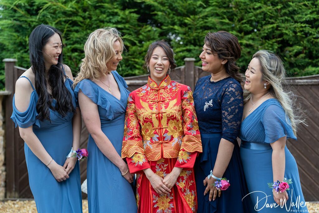 Multicultural bridesmaids laughing together at wedding.