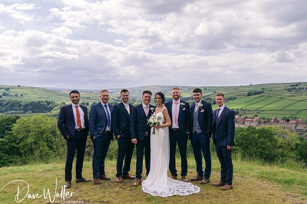 Bride and groom with groomsmen in countryside setting.