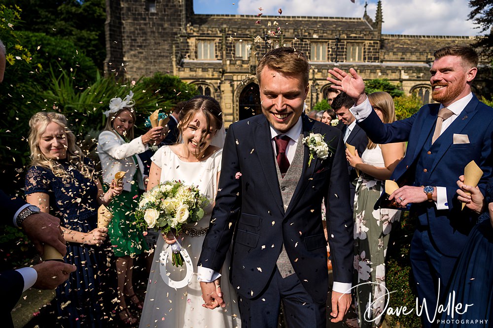 Couple smiling during wedding confetti toss.