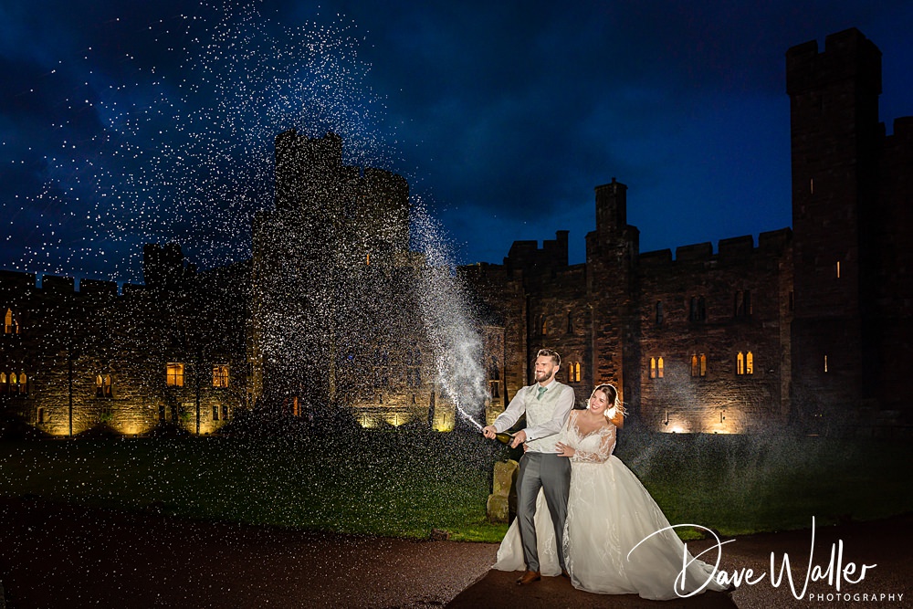 Couple with sparklers by castle at night.