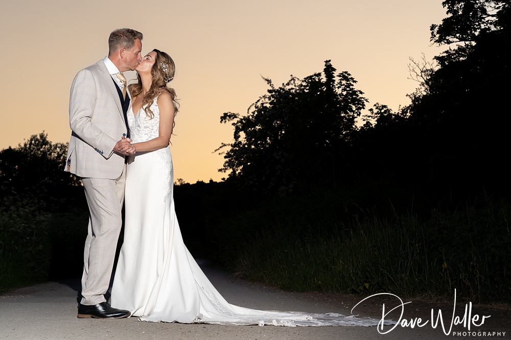 Couple kissing at dusk, outdoor wedding photography