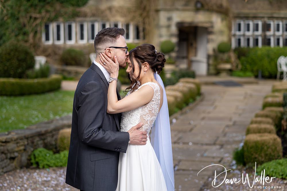 Bride and groom sharing a kiss outdoors.