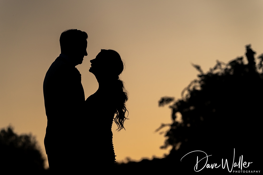 Silhouetted couple at sunset, romantic atmosphere.