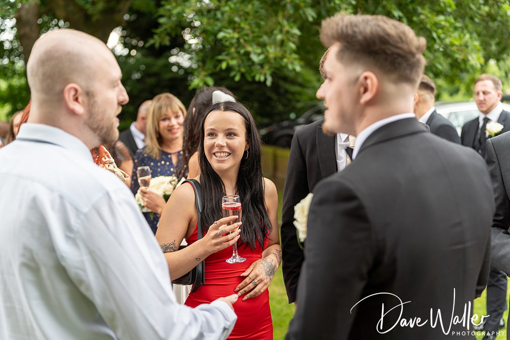 People socialising outdoors at a wedding.