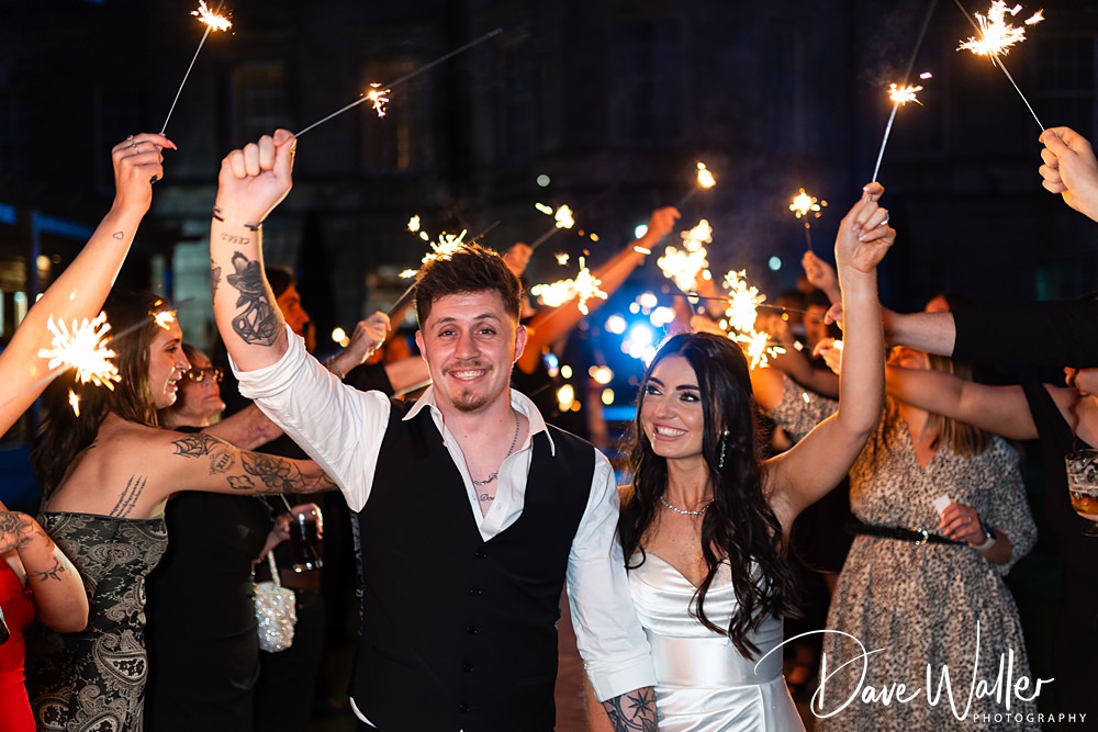Couple celebrating with sparklers at night party.