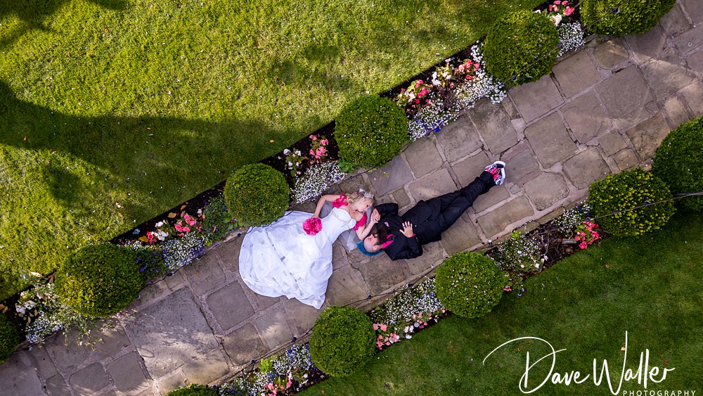 Bride and groom laying on garden path