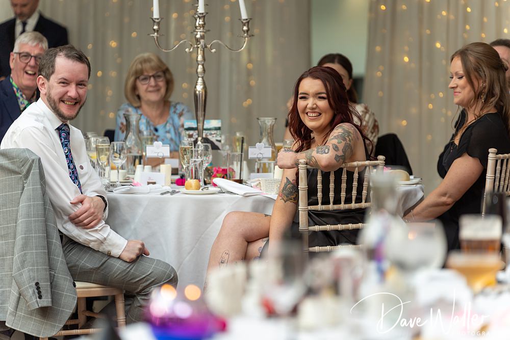 People smiling at a wedding reception.