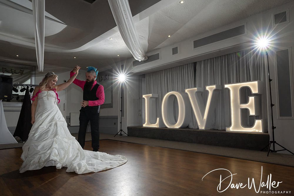 Couple's first dance at wedding with love sign