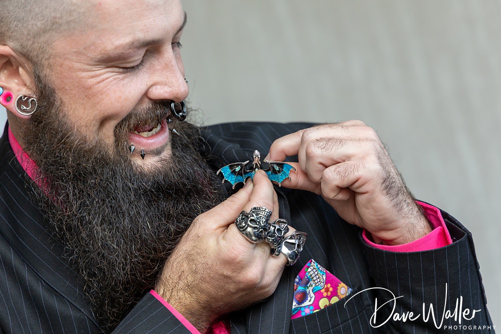 Man holding miniature blue-winged creature, smiling.