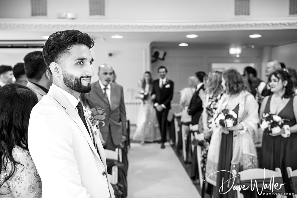 Groom waiting at the altar, guests seated.