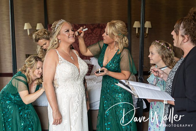 Bridal party preparing, bridesmaids in green dresses.