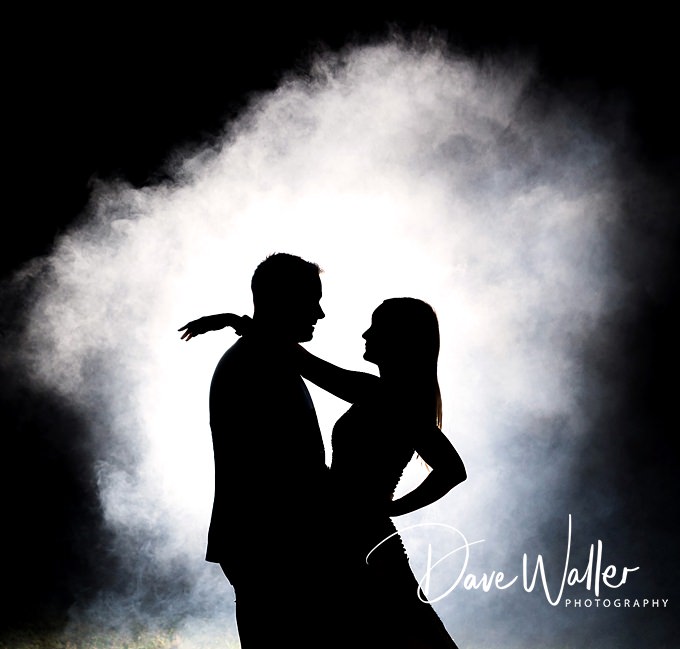 Silhouetted couple embracing against smoky backdrop