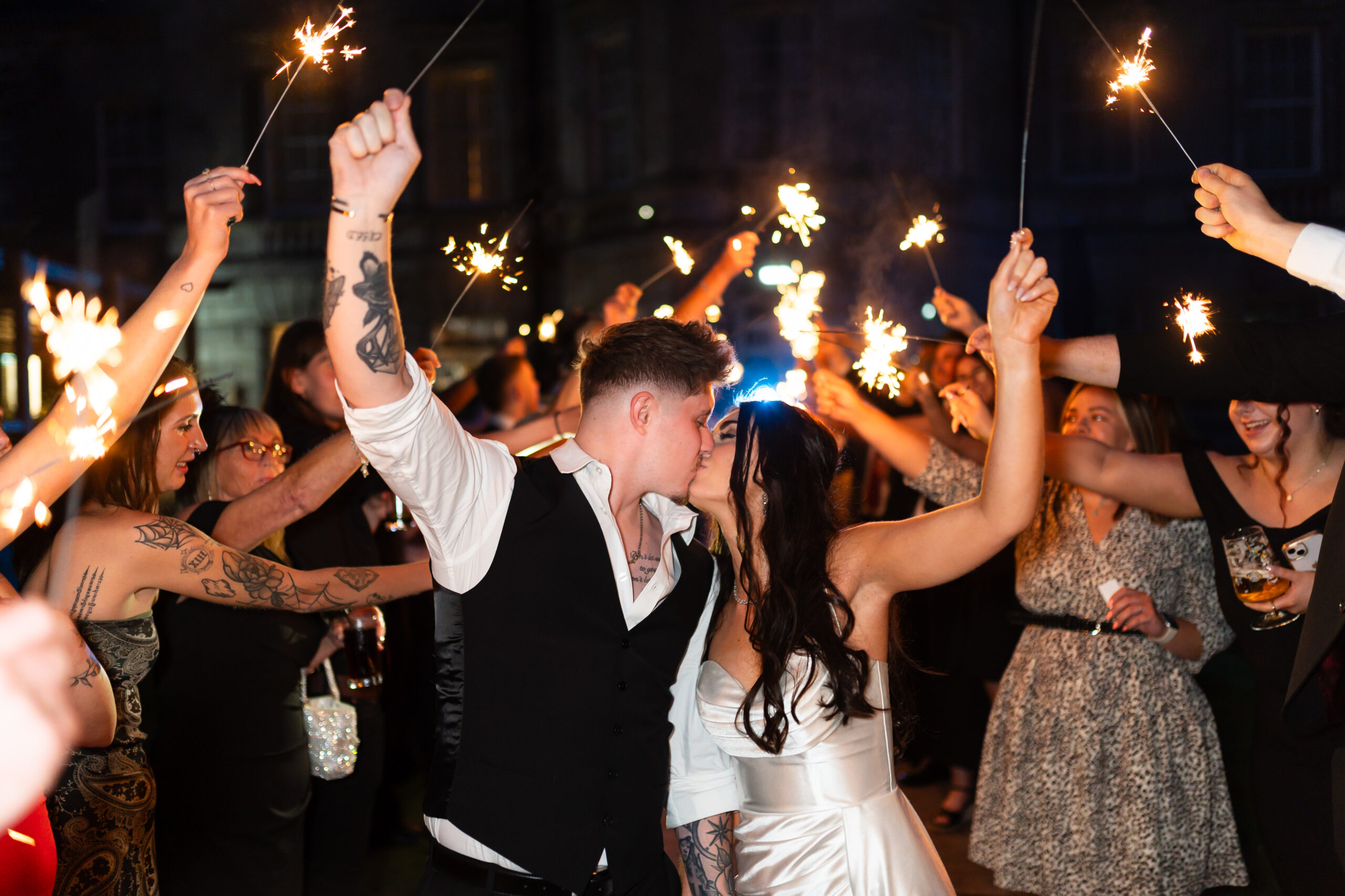 Couple kissing during sparkler wedding celebration