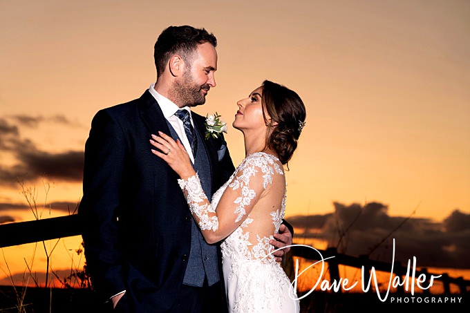 Bride and groom at sunset, romantic wedding moment.