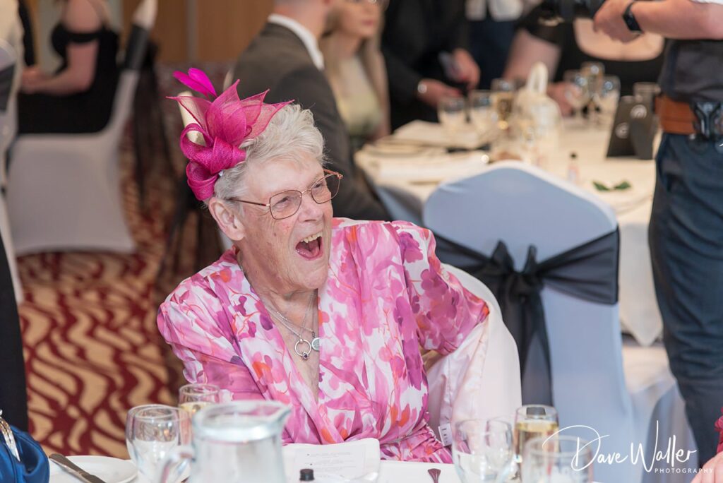 Elderly woman laughing at formal event table