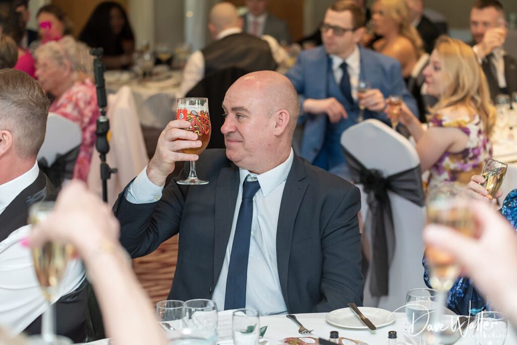 Man in suit toasting with beer at banquet