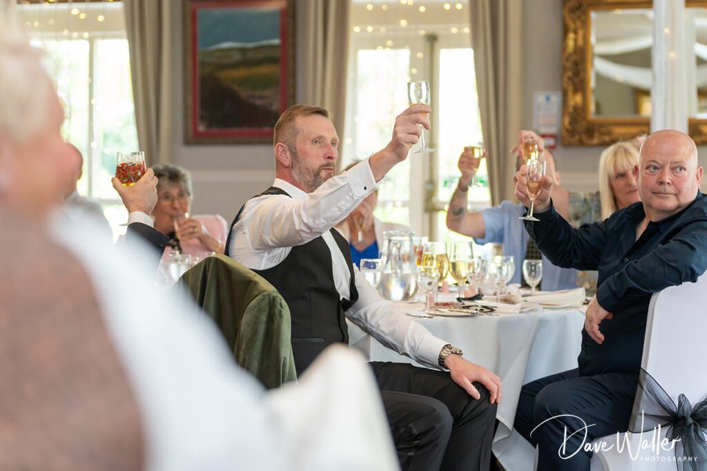 Guests raising glasses for a celebratory toast indoors