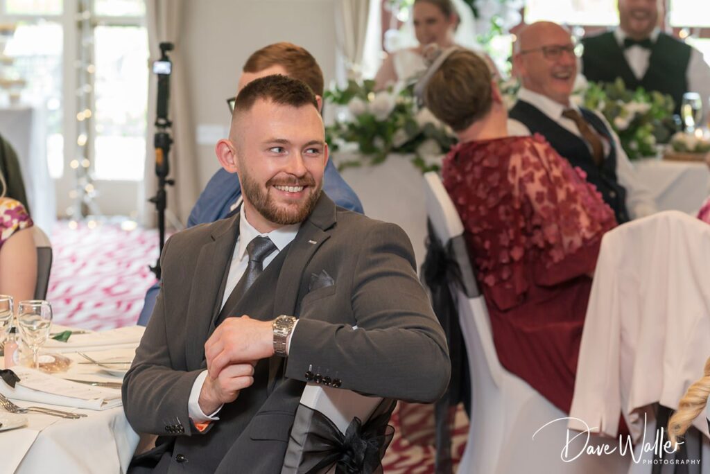 Smiling man in suit at wedding reception