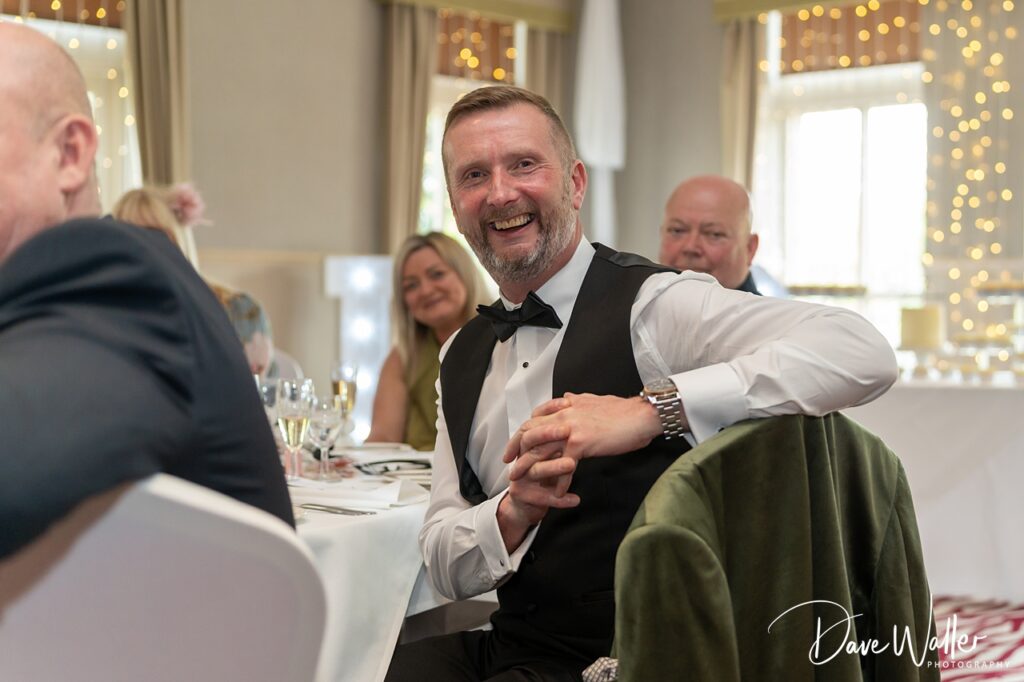 Smiling man in tuxedo at wedding reception