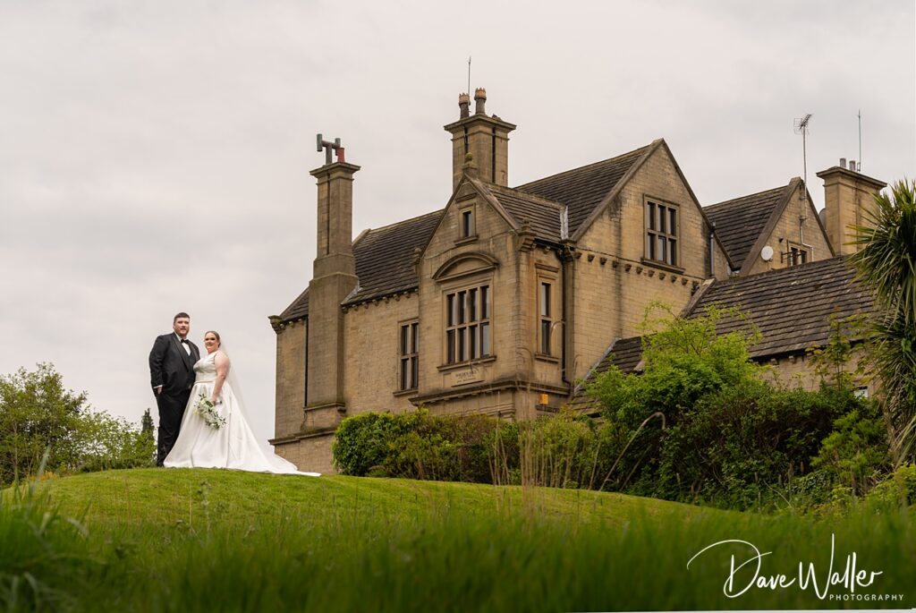 Bride and groom outside historic stone manor