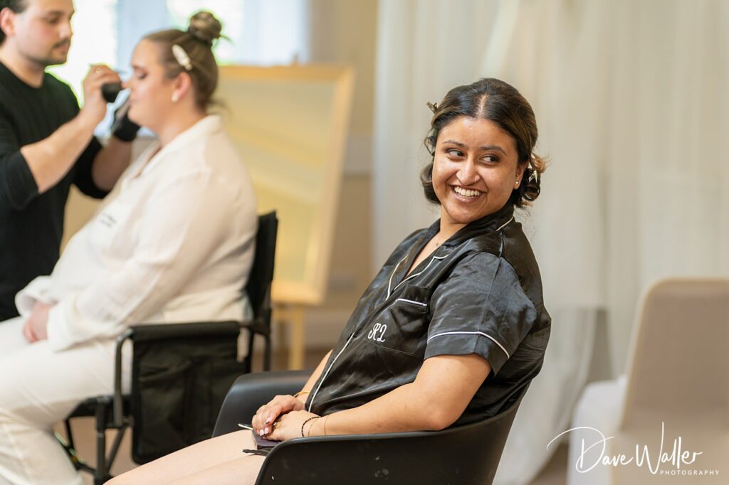 Woman smiling during bridal makeup preparations