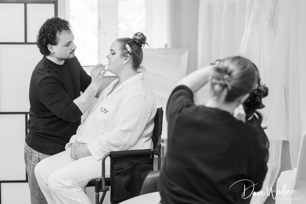 Makeup artist preparing bride during photoshoot