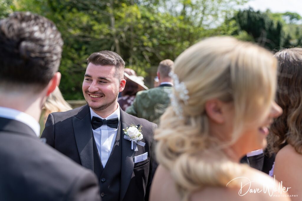 Smiling groom in tuxedo at outdoor wedding