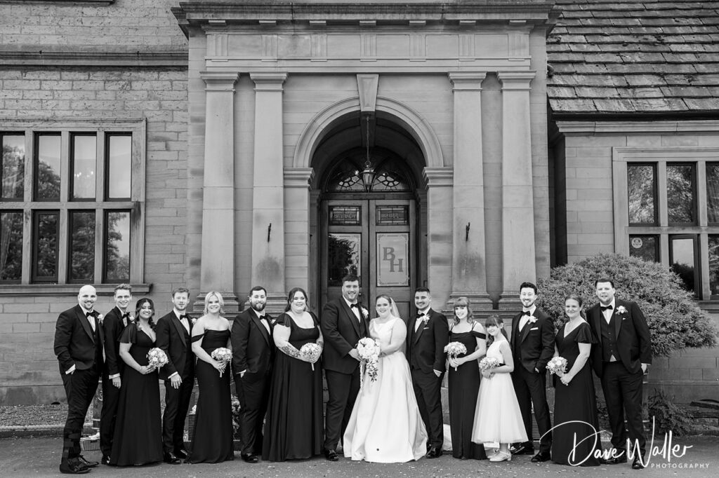 Wedding party outside grand stone building entrance