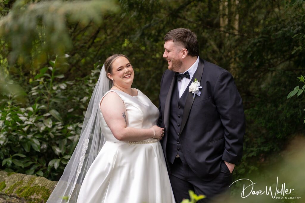 Bride and groom smiling in woodland setting