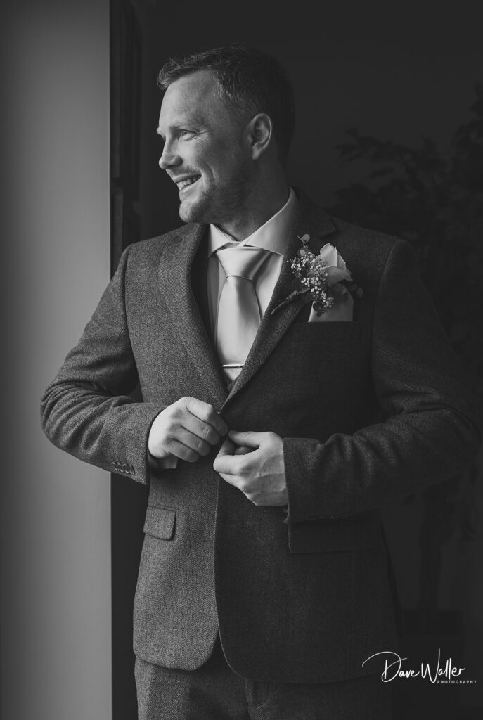 Man smiling in suit with boutonniere.