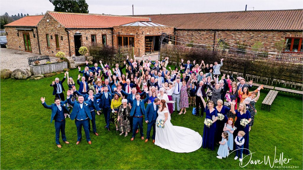 Large wedding group celebrating outdoors.