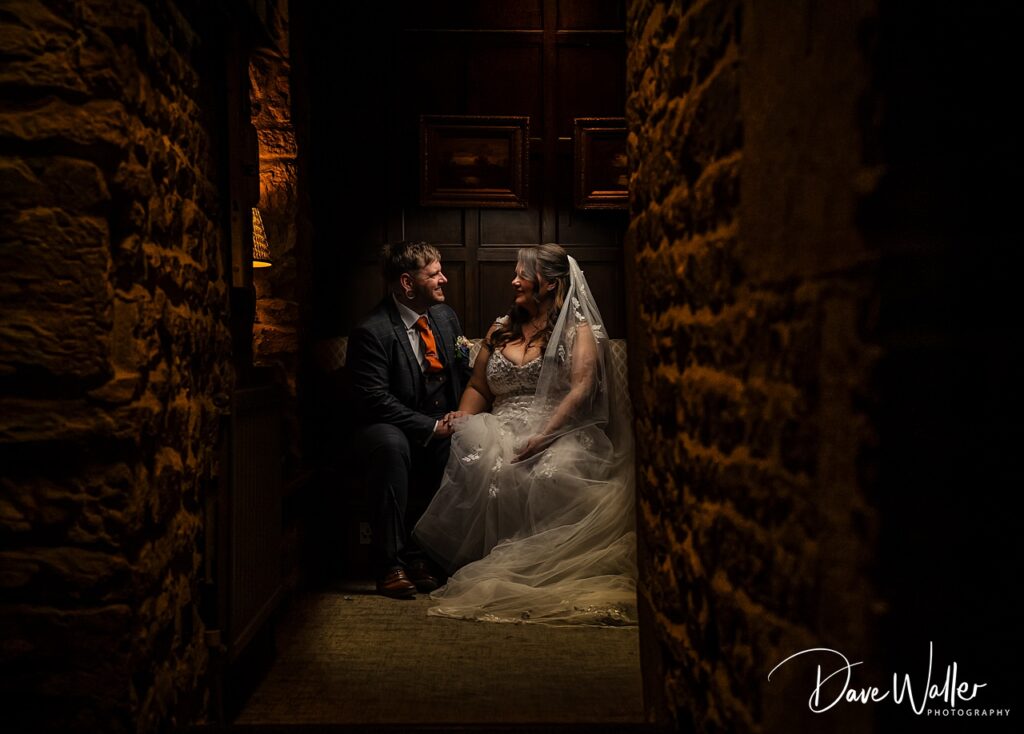 Bride and groom sitting in dimly lit corridor
