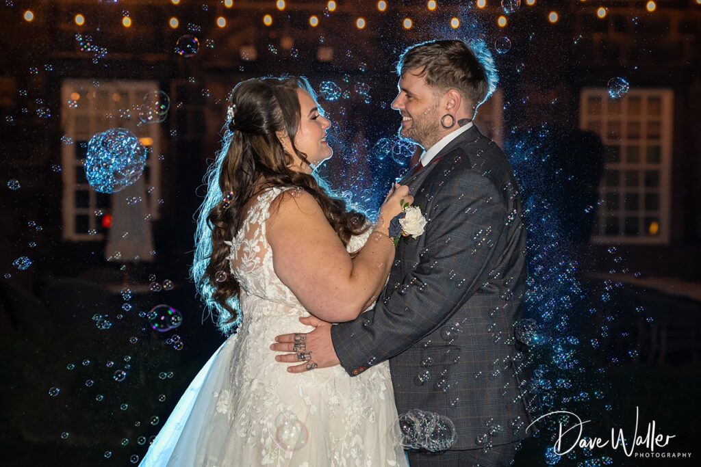 Bride and groom dancing surrounded by bubbles.