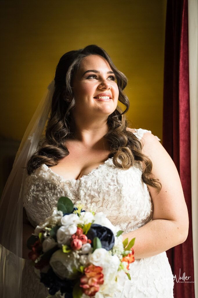 Happy bride holding bouquet in wedding dress