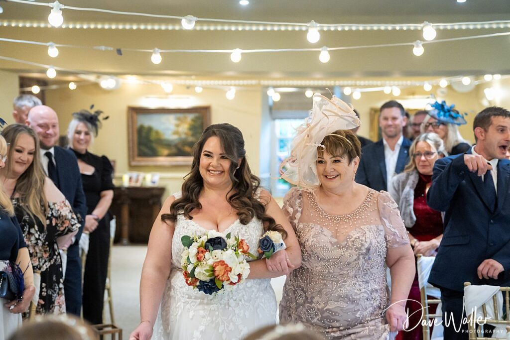 Bride walking down the aisle with family.