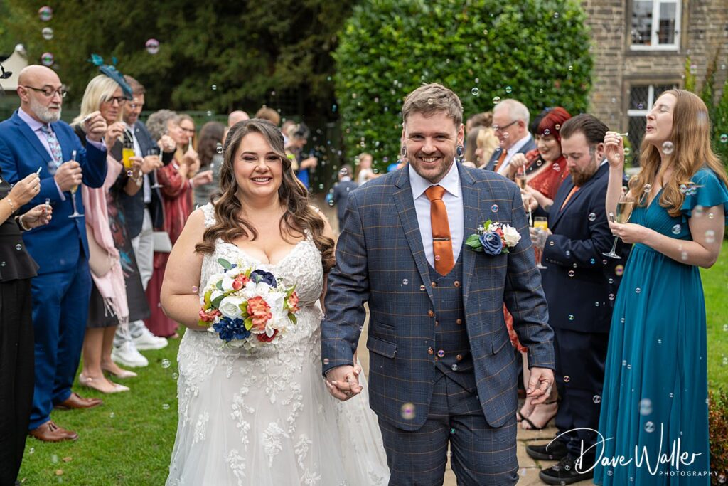 Bride and groom celebrating with guests and bubbles.
