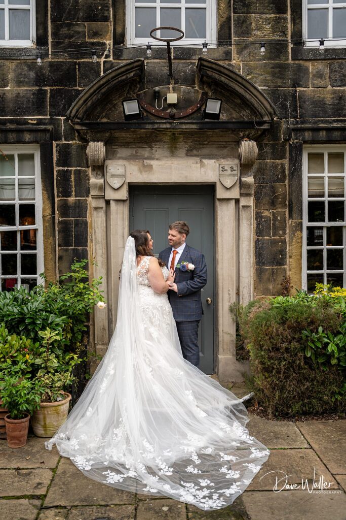 Bride and groom smiling outside historic building.