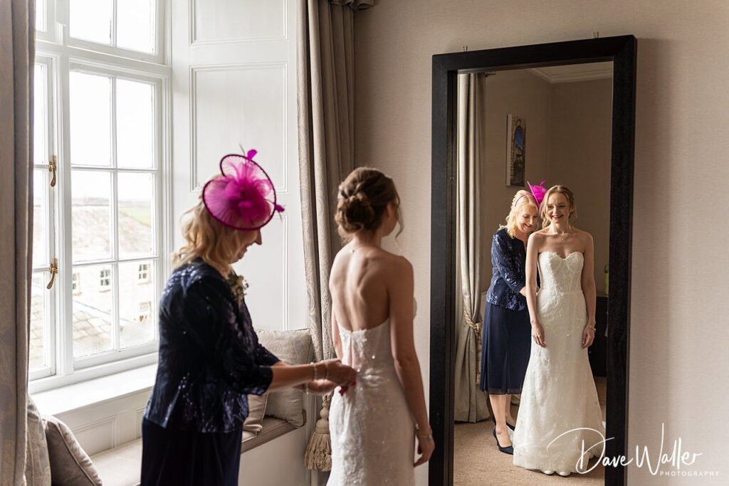 Bride getting ready with help from woman