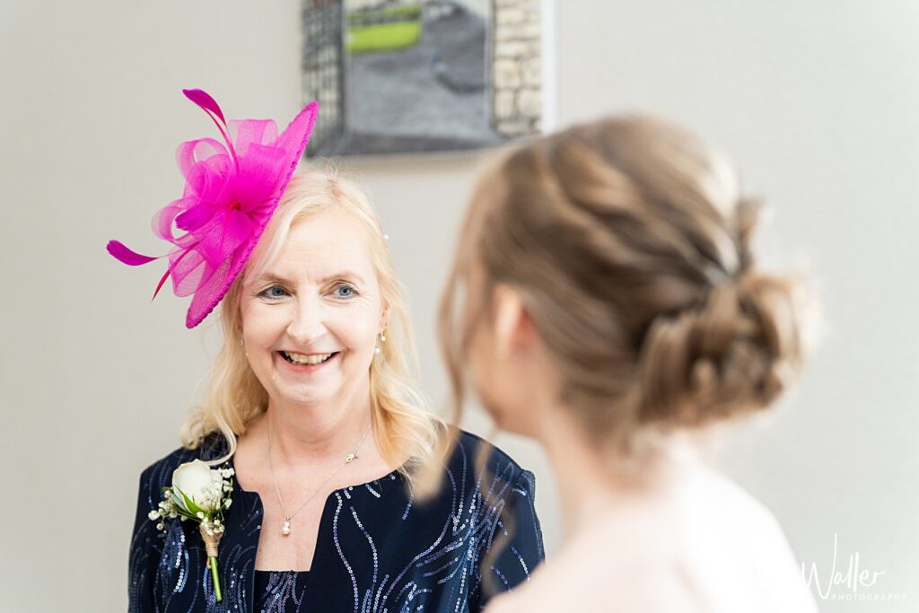 Smiling woman in pink fascinator at event