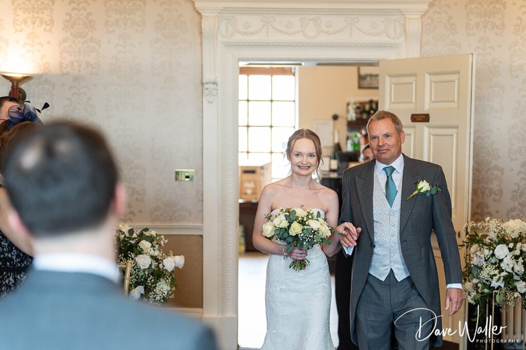 Bride and father entering room, wedding ceremony.